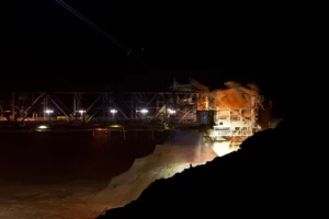 Industrial bucket-wheel excavator operating at night in a Southern African open-pit mine, highlighting the need for reliable UPS power solutions like those offered by Standby Systems and AROS Riello UPS.